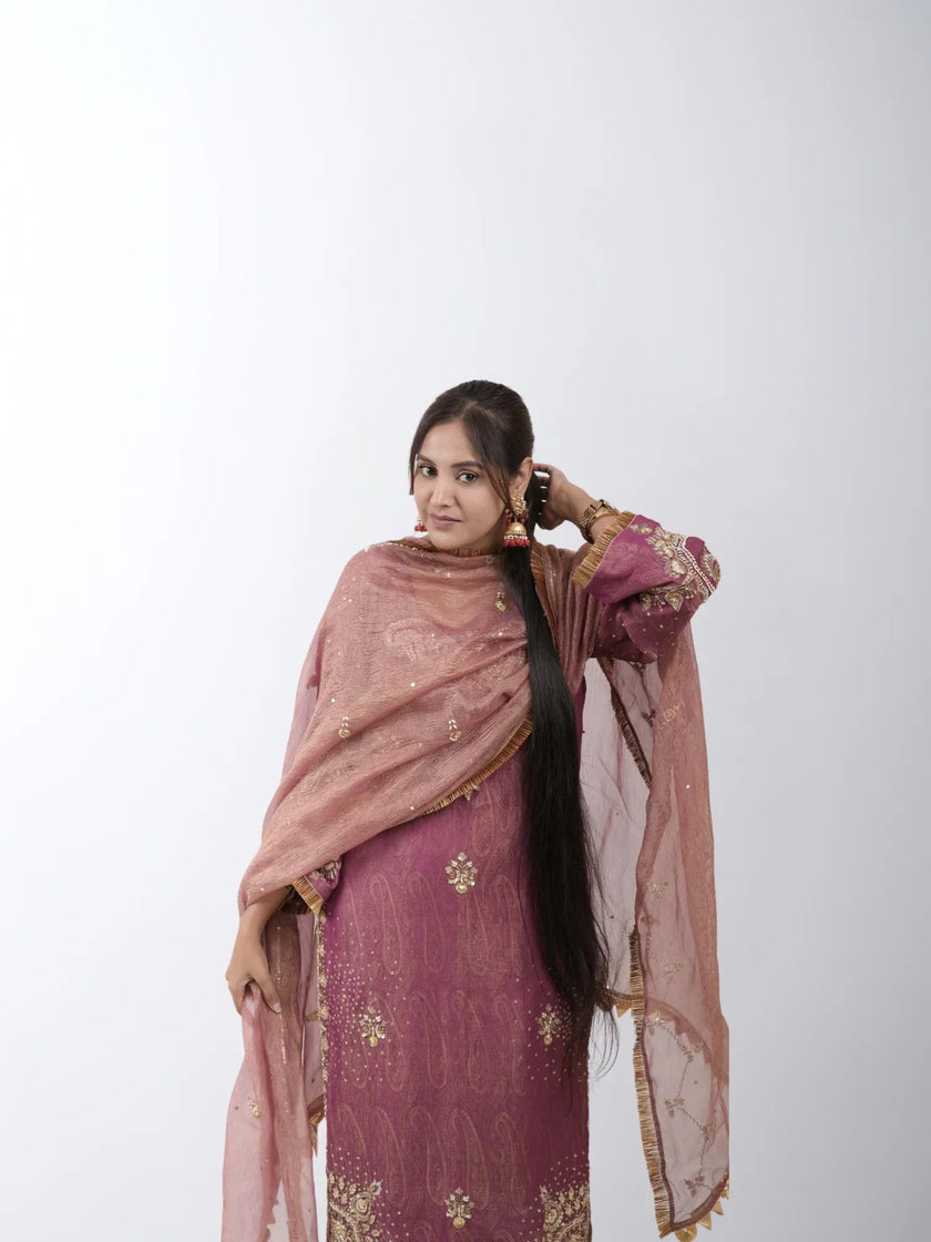 A woman with long, beautifully braided hair adorned with traditional accessories, showcasing the elegance of 100% human Remy hair and Hair Haux extensions