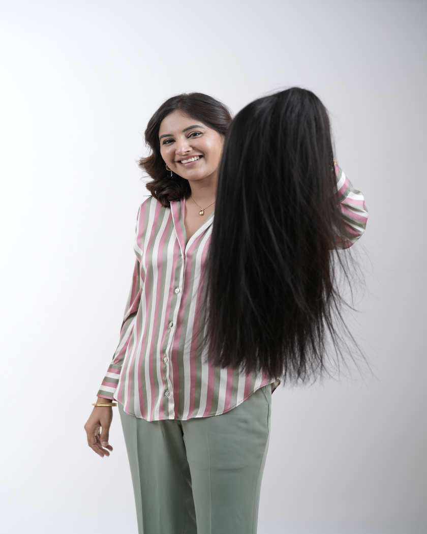 A woman with long, shiny hair styled effortlessly, showcasing the beauty of 100% human remy hair extensions from Hair Haux