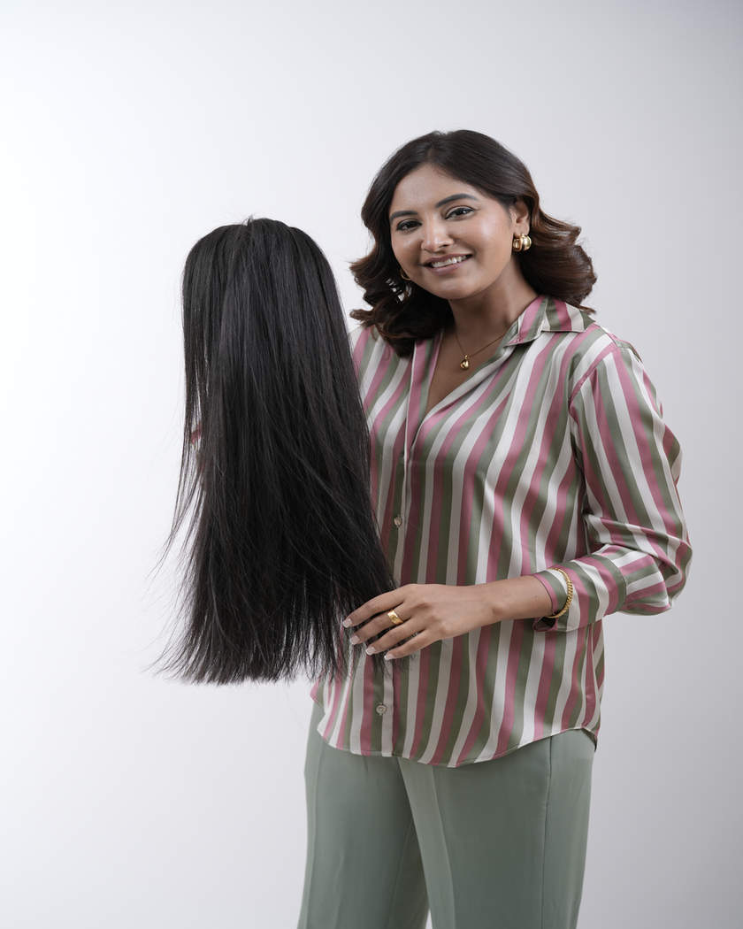 A woman with long, voluminous Hair Haux extensions styled in soft waves, showcasing the beauty of 100% human remy hair for a natural, flawless look